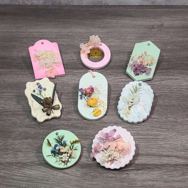 手工製作擴香石花藝牌，白色石膏底座配搭乾燥花裝飾，放置於木質桌面